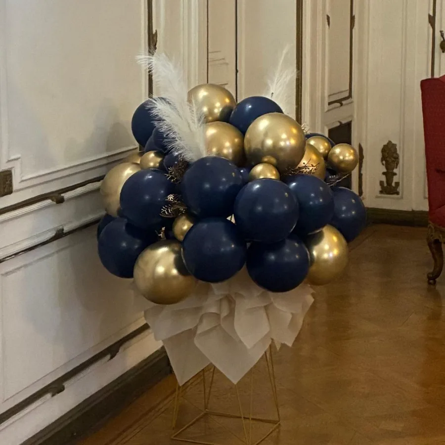 Detalle de centro decorativo boutique en azul marino y dorado con plumas